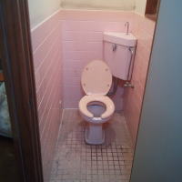 トイレ内装工事前の写真です。タイル壁や床が古くて汚れています。